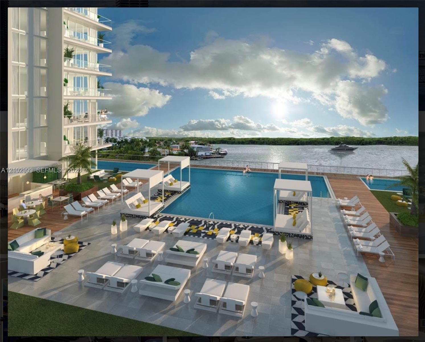 Expansive pool deck with multiple swimming pools, waterfront access, and a multi-story building featuring private balconies