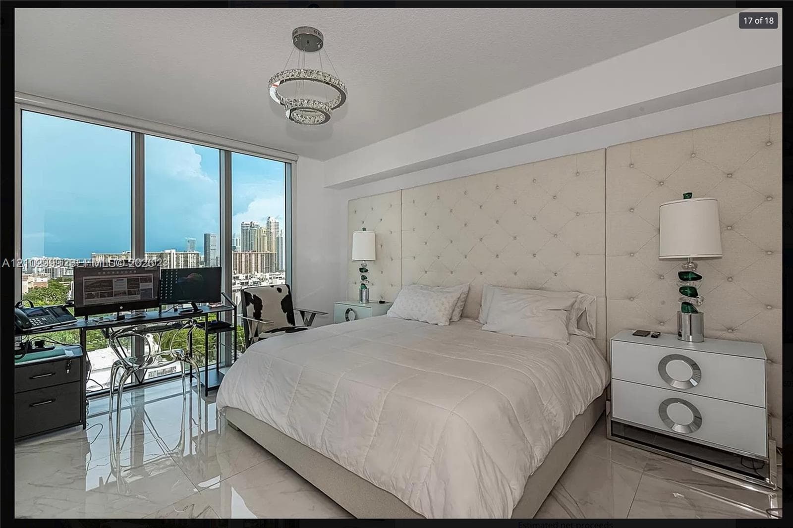 Floor-to-ceiling windows, polished tile flooring, recessed lighting, and a tufted upholstered wall panel