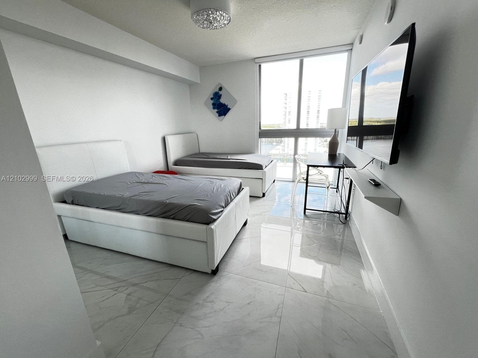 Floor-to-ceiling windows, polished stone-finish flooring, wall-mounted floating shelf, and contemporary flush-mount ceiling lighting