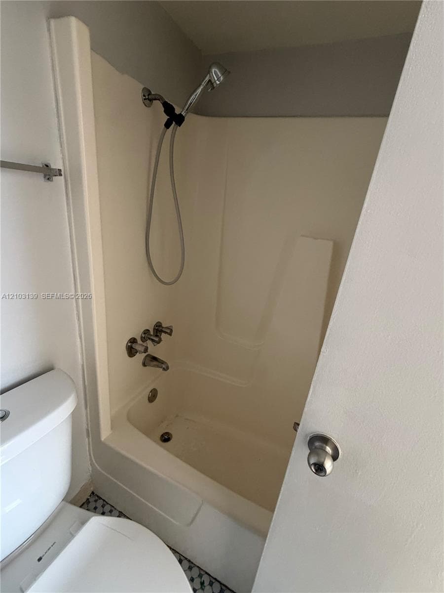Full-height window, light-toned tiled flooring, and neutral wall paint
