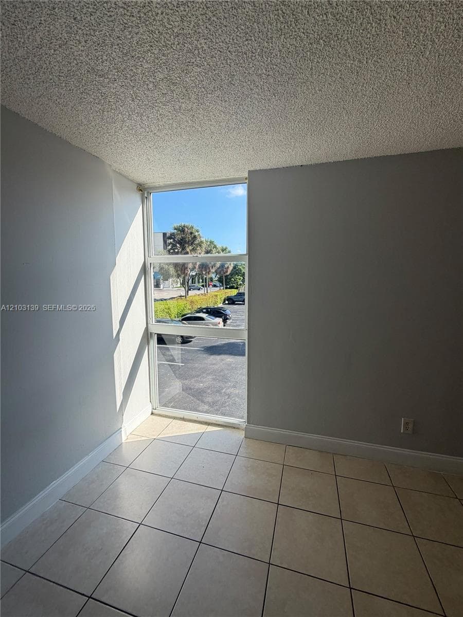 Full-height window, light-toned tiled flooring, and neutral wall paint