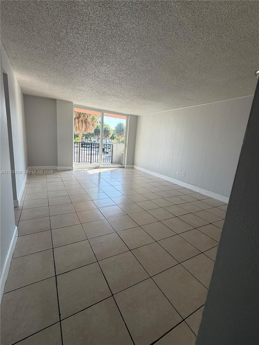 Expansive room with tiled flooring and light-toned walls