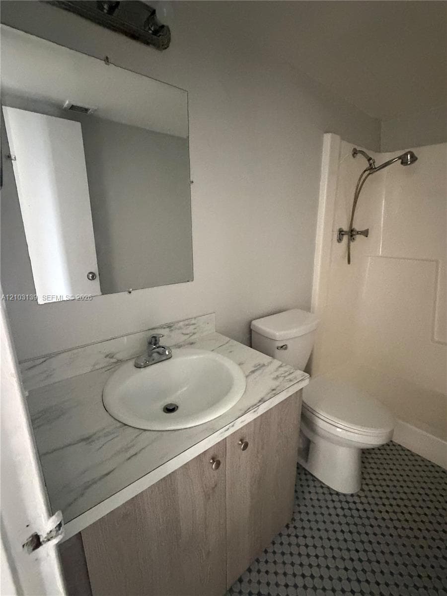 Vanity with a white oval basin and a chrome faucet, set on a marble-finish countertop