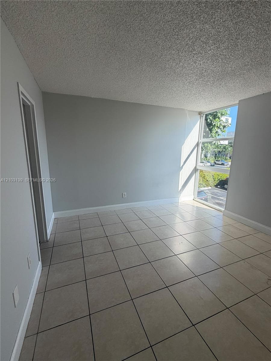 Tile flooring, light gray walls, white trim, and a prominent window