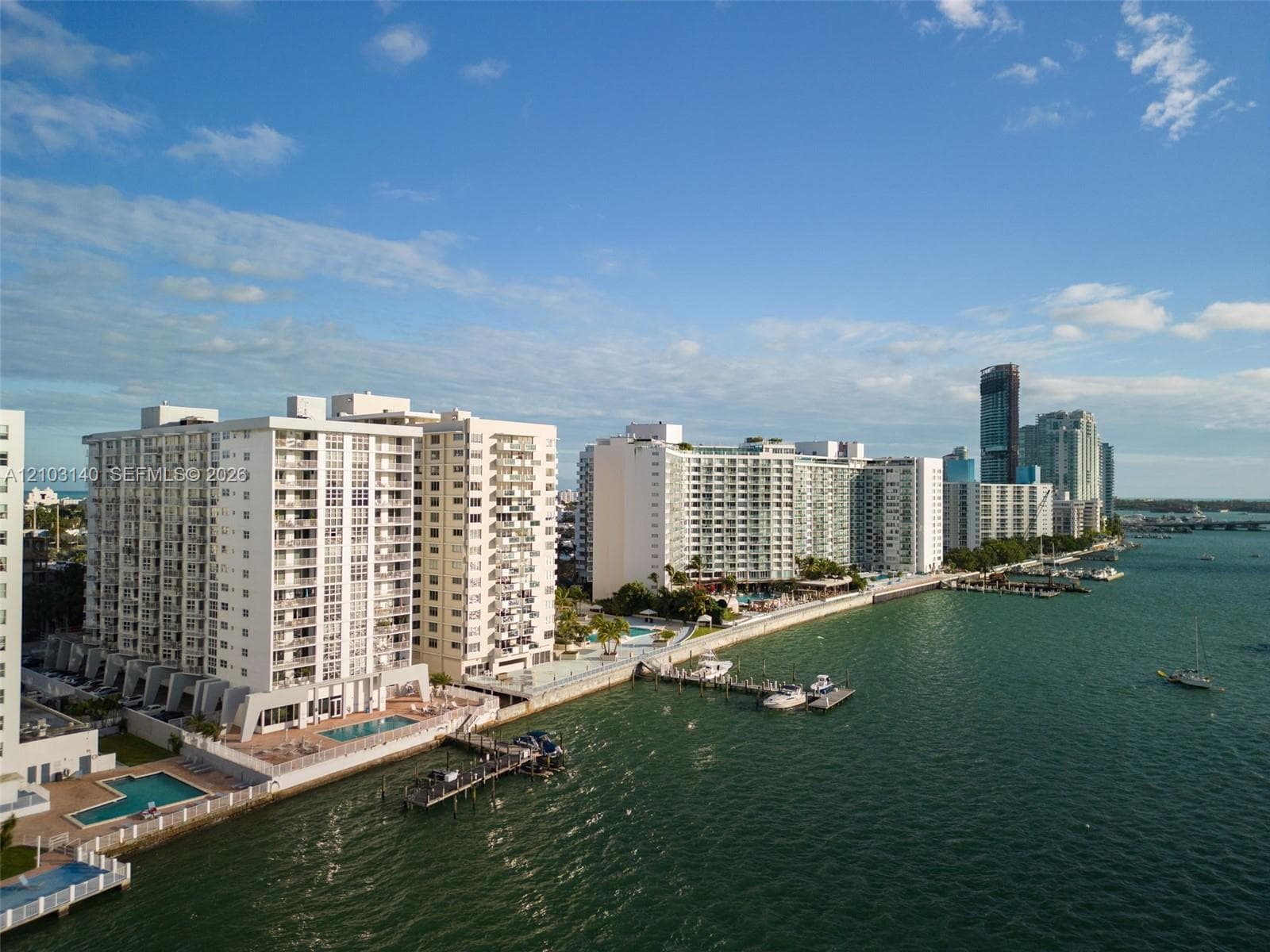 Waterfront high-rise building featuring private boat docks, swimming pools, paved sun decks, and multi-level balconies