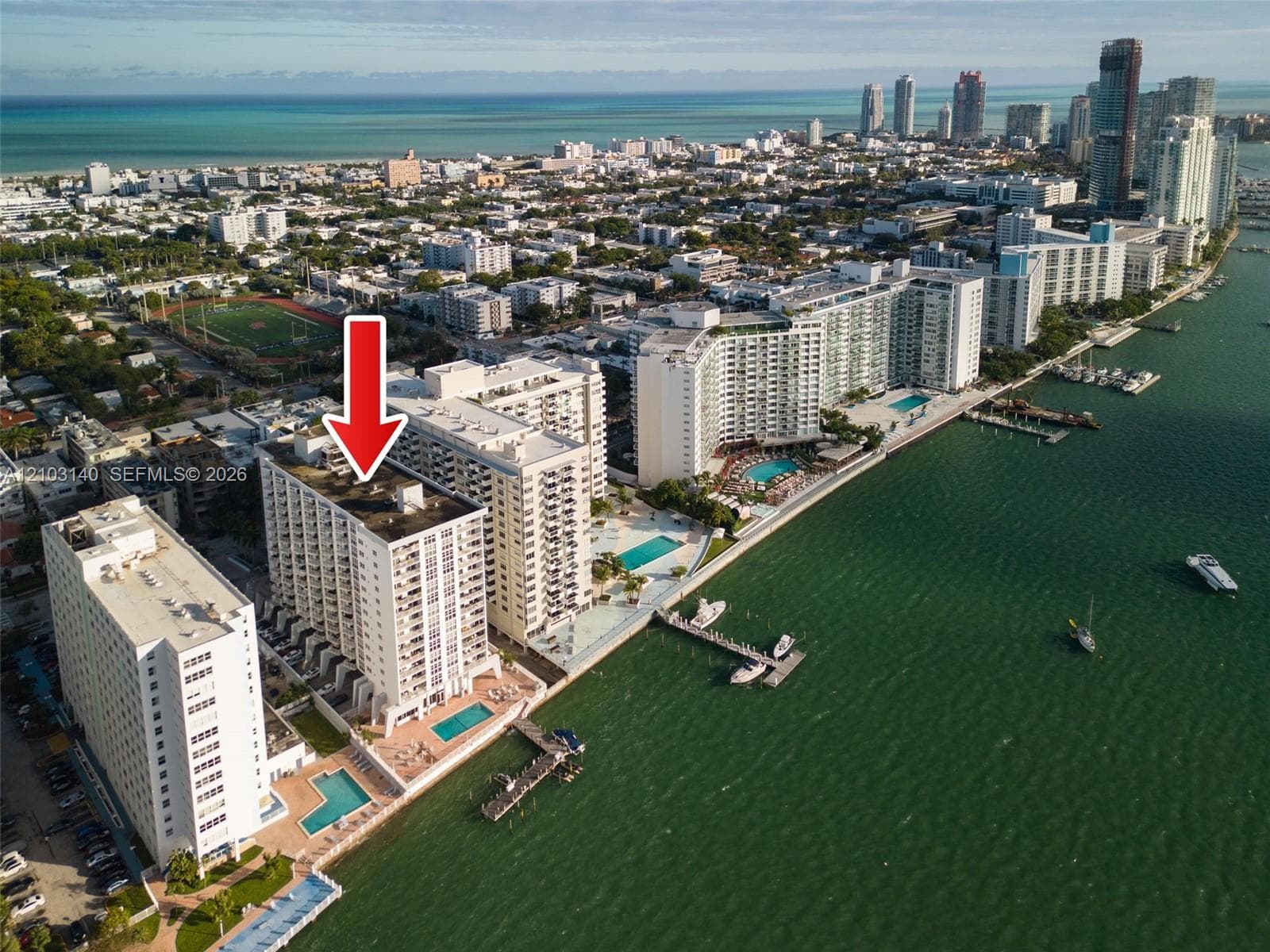 High-rise residential building featuring exterior balconies, a waterfront swimming pool, and private boat dockage