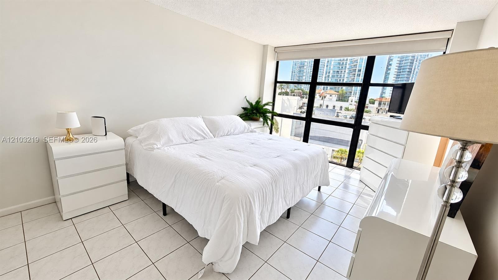 Floor-to-ceiling multi-pane window with black framing and white tile flooring