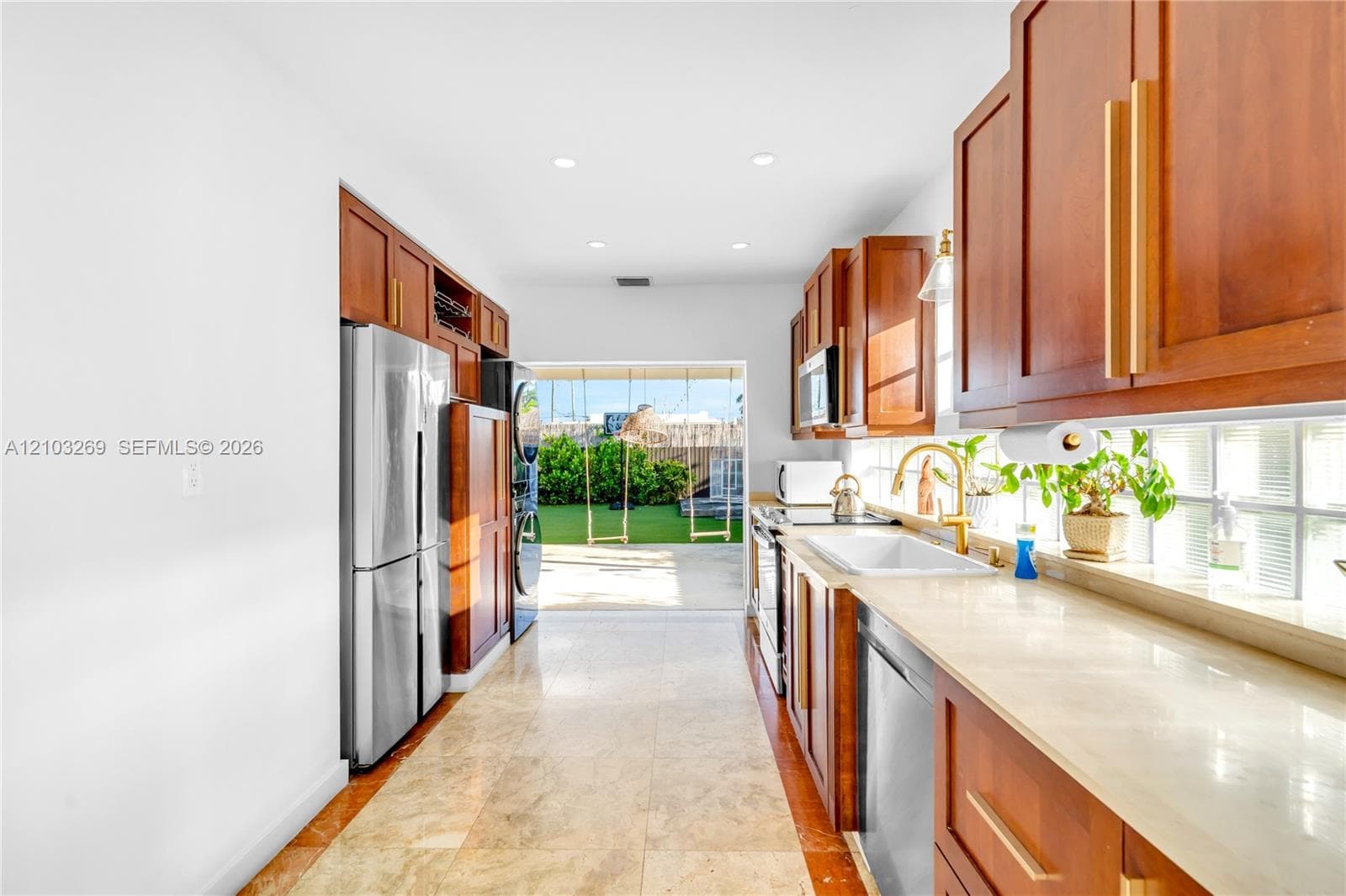 Kitchen featuring wood cabinetry, stone-finish countertops, stainless steel appliances, a farmhouse-style sink, and recessed lighting
