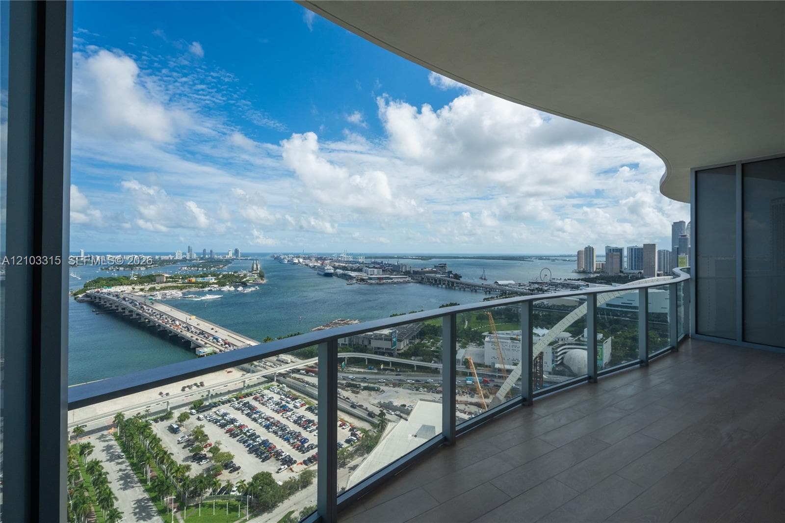 Expansive balcony with wood-finish flooring and a glass railing