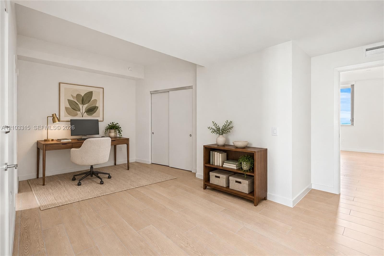 Light wood-finish flooring, white walls, and a sliding closet door