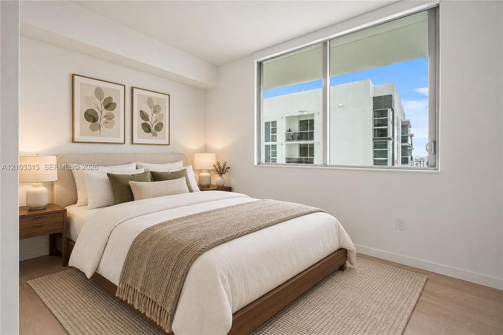 Expansive window with roller shades, light wood-finish flooring, and crisp white walls