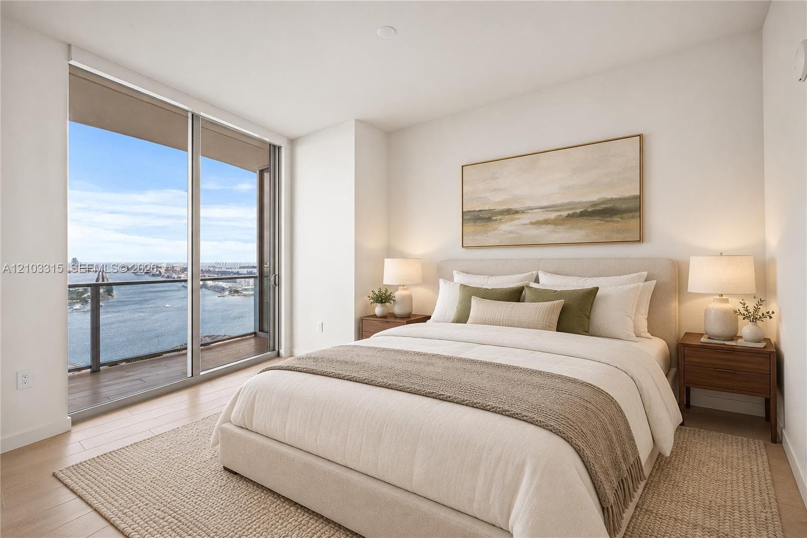 Full-height sliding glass doors leading to an exterior balcony, light wood-finish flooring, and white painted walls