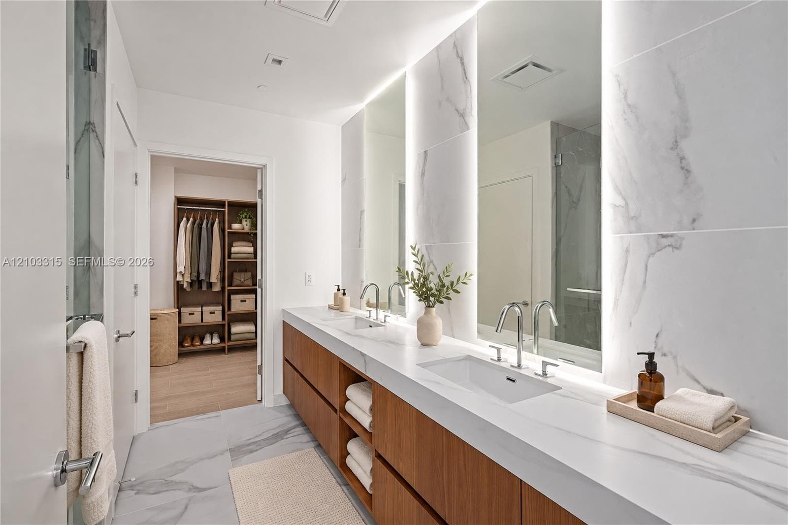 Dual vanity with integrated sinks, wood-finish cabinetry, and polished chrome fixtures