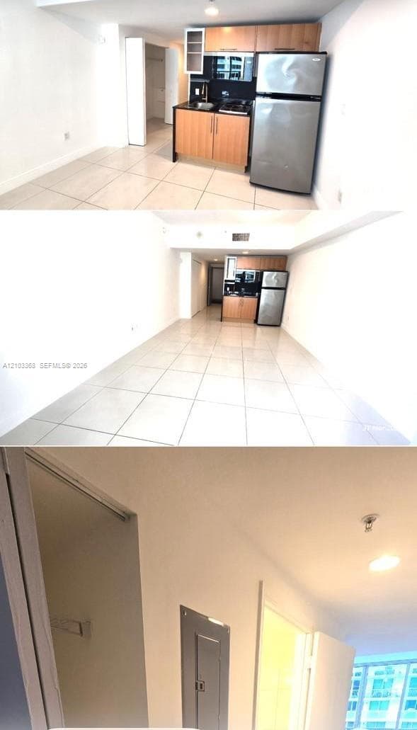 Kitchen featuring flat-panel wood-finish cabinetry, stainless steel refrigerator, integrated cooktop, and tile flooring throughout