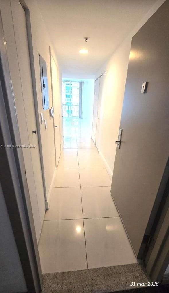 Entryway featuring large-format polished tile flooring, smooth white walls, recessed ceiling lighting, and solid-core interior doors