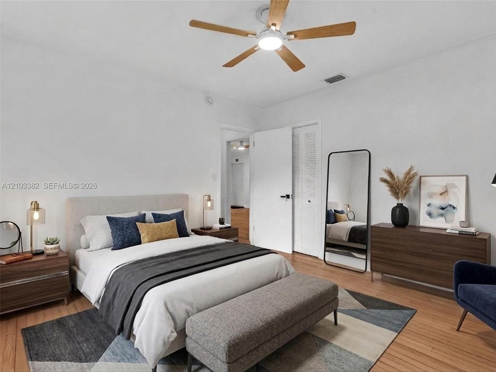 VIRTUAL STAGING. East bedroom featuring wood-finish flooring, a ceiling fan with integrated lighting, and louvered-panel closet doors. House for rent in Coral Gables. House for rent listed by Realtor.