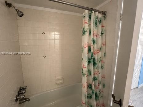 Tub and shower combination with white square wall tile, integrated soap dish, and chrome-finish fixtures