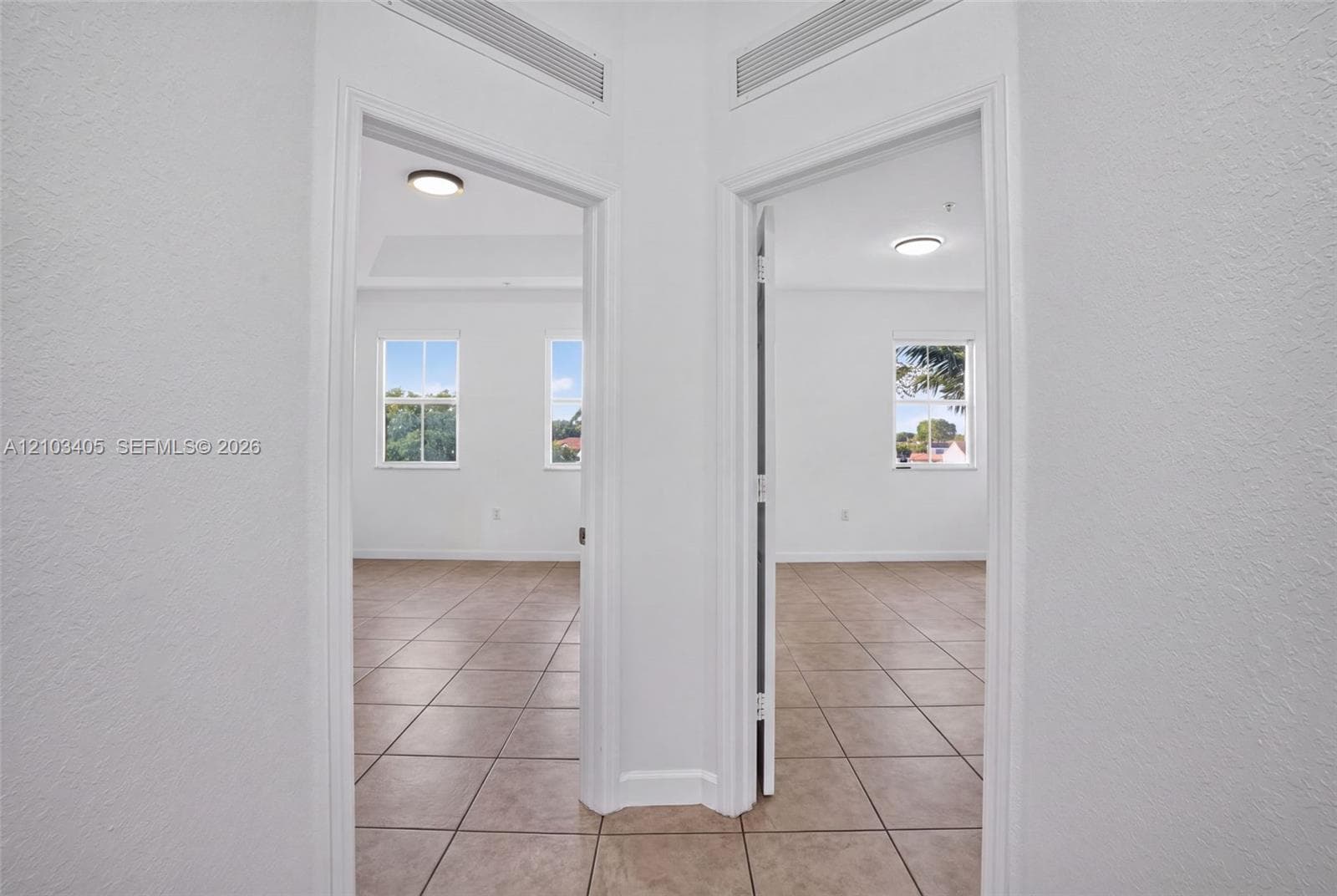 Ceramic tile flooring, white wall finish, recessed ceiling lighting, and dual entryways