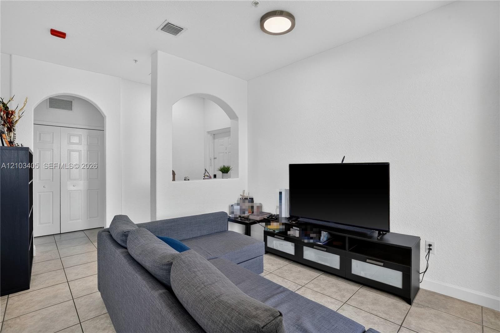 Entrance featuring a paneled entry door, metal perimeter railing, textured wall finish, and an electronic smart lock