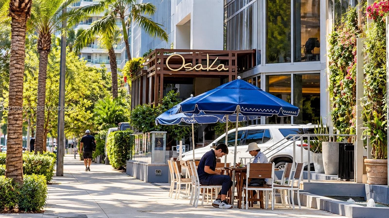 Exterior restaurant patio featuring a blue umbrella and outdoor seating