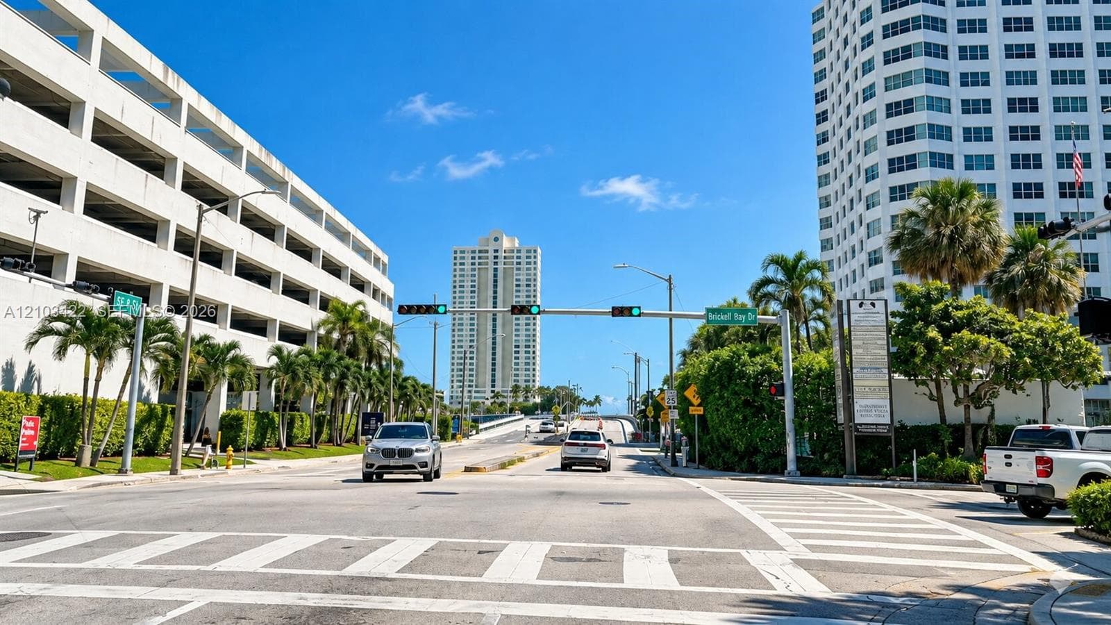 Cityscape featuring multi-story buildings, palm trees, and clear blue skies