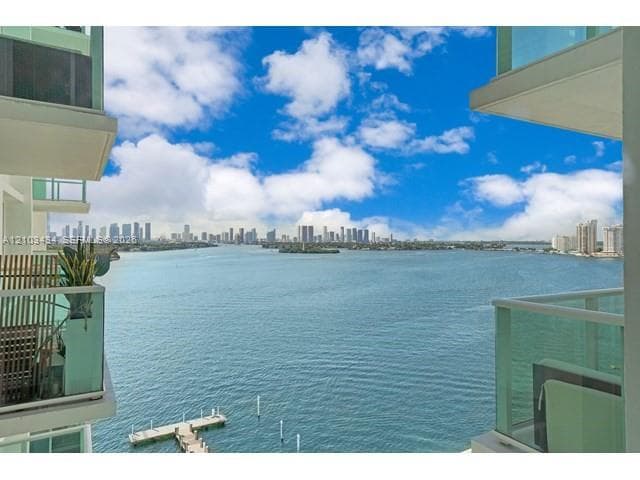 Private balcony featuring glass railings and expansive water, cityscape, and skyline scenery