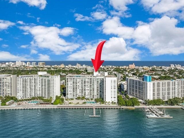 Waterfront high-rise building with a private pier, outdoor pool, and proximity to the coastline