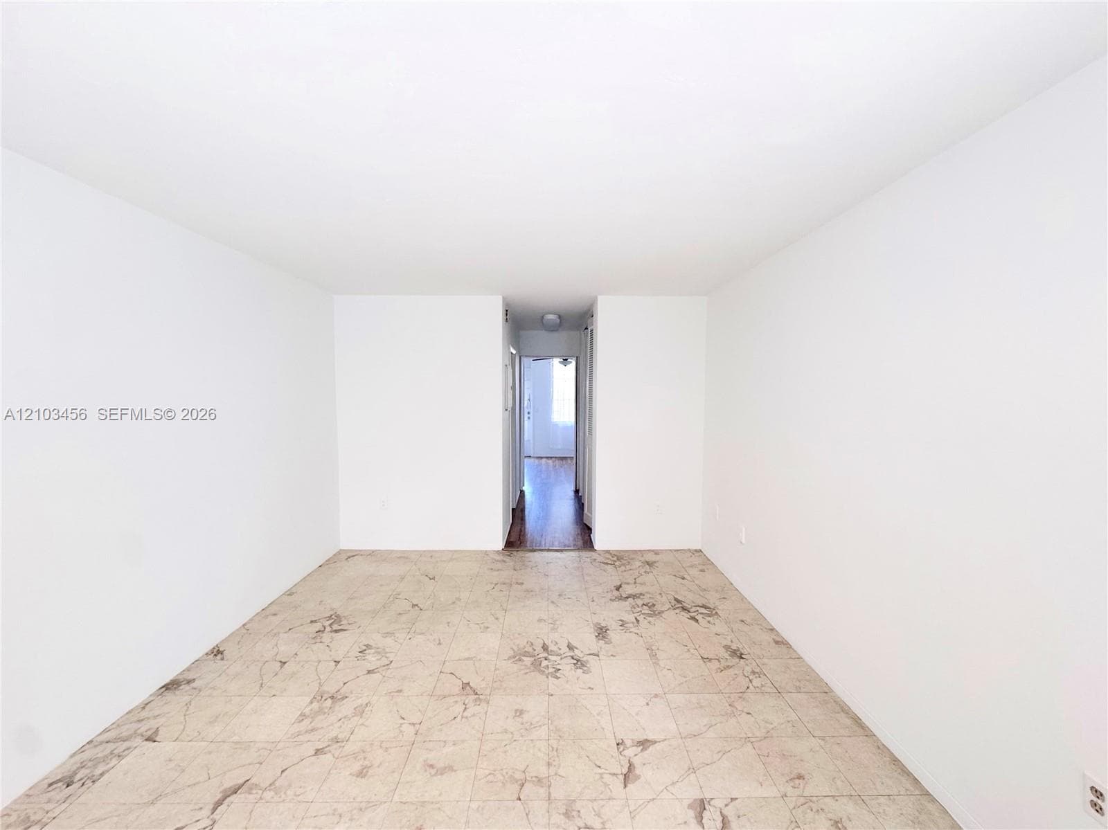 Interior space featuring high-contrast neutral wall finishes and large-format tile flooring with marble-pattern detailing