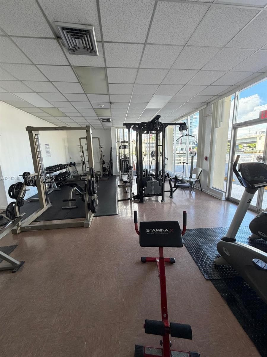 Fitness facility featuring floor-to-ceiling windows and tile flooring