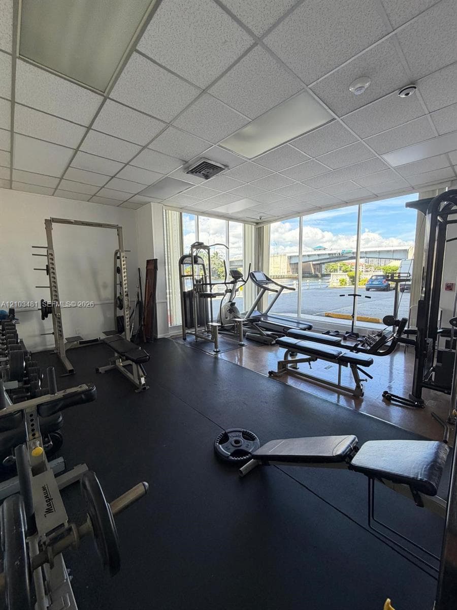 Fitness room featuring floor-to-ceiling windows, durable rubber flooring, and recessed ceiling lighting