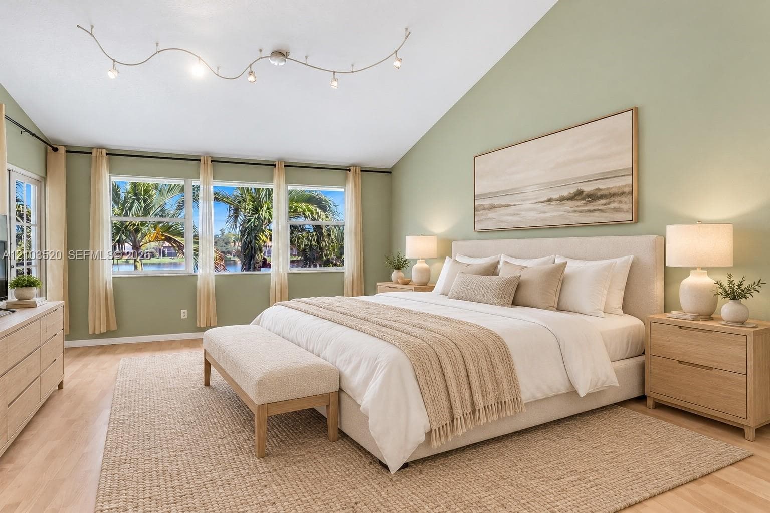 Vaulted ceiling with modern multi-point track lighting, wood-finish flooring, and expansive windows