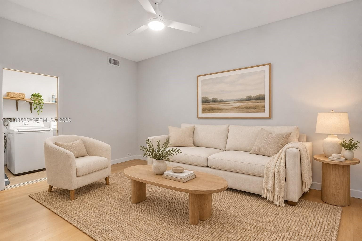 Neutral-toned interior featuring wood-finish flooring and a ceiling-mounted light fixture with an integrated fan