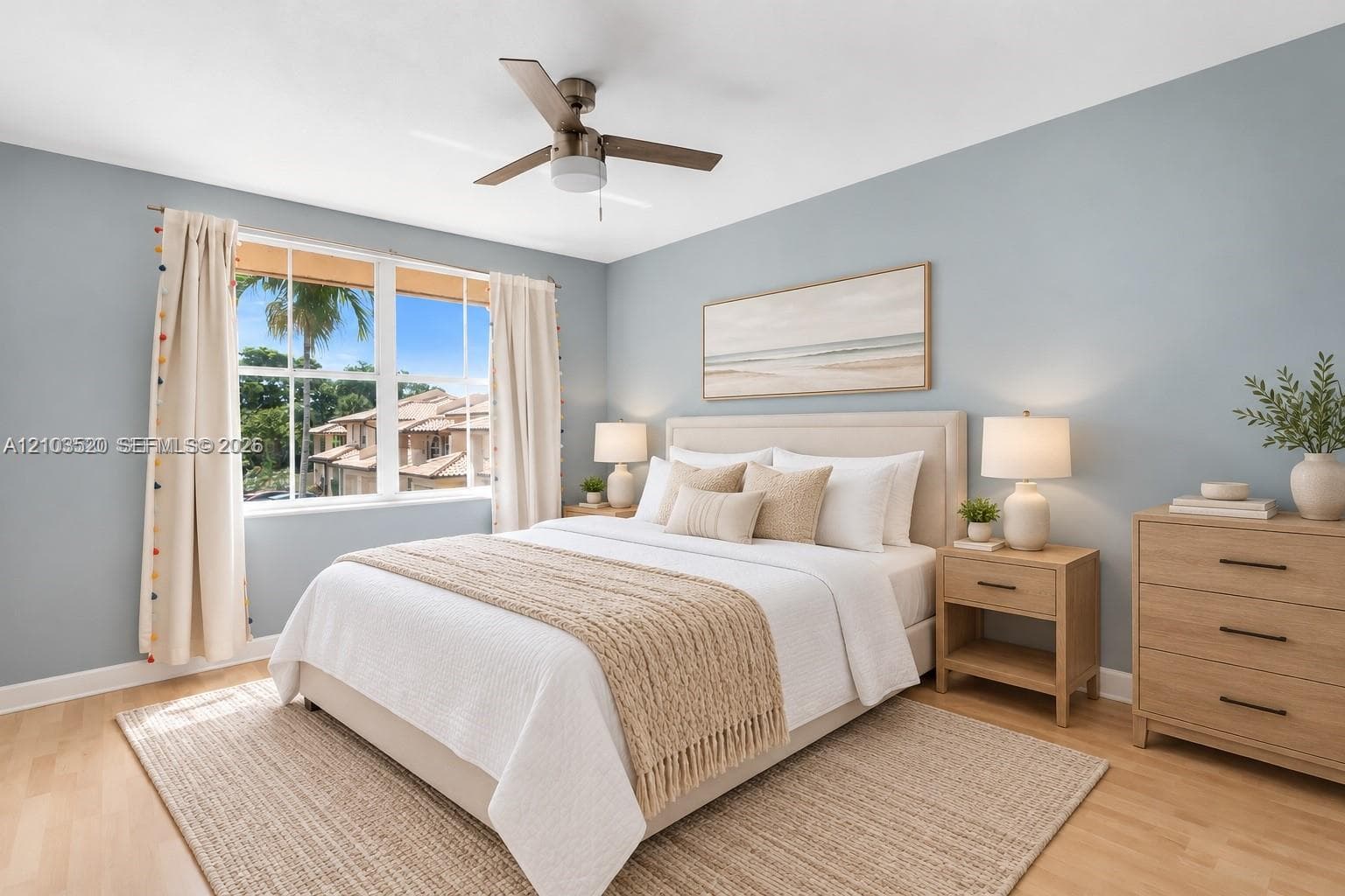 Room featuring light-toned wood-finish flooring, a multi-pane window, and a ceiling fan with integrated light fixture