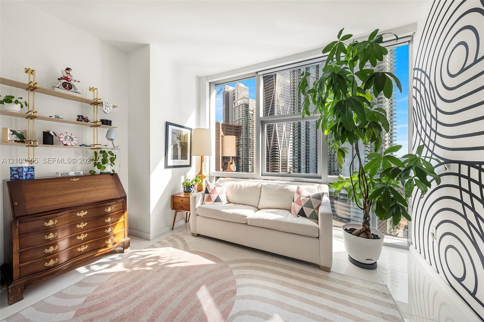 Floor-to-ceiling windows, light-toned flooring, built-in shelving, and a decorative wall accent