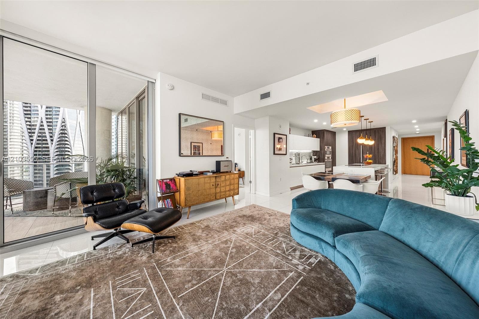 Open-concept living area with a balcony, recessed lighting, and tile flooring