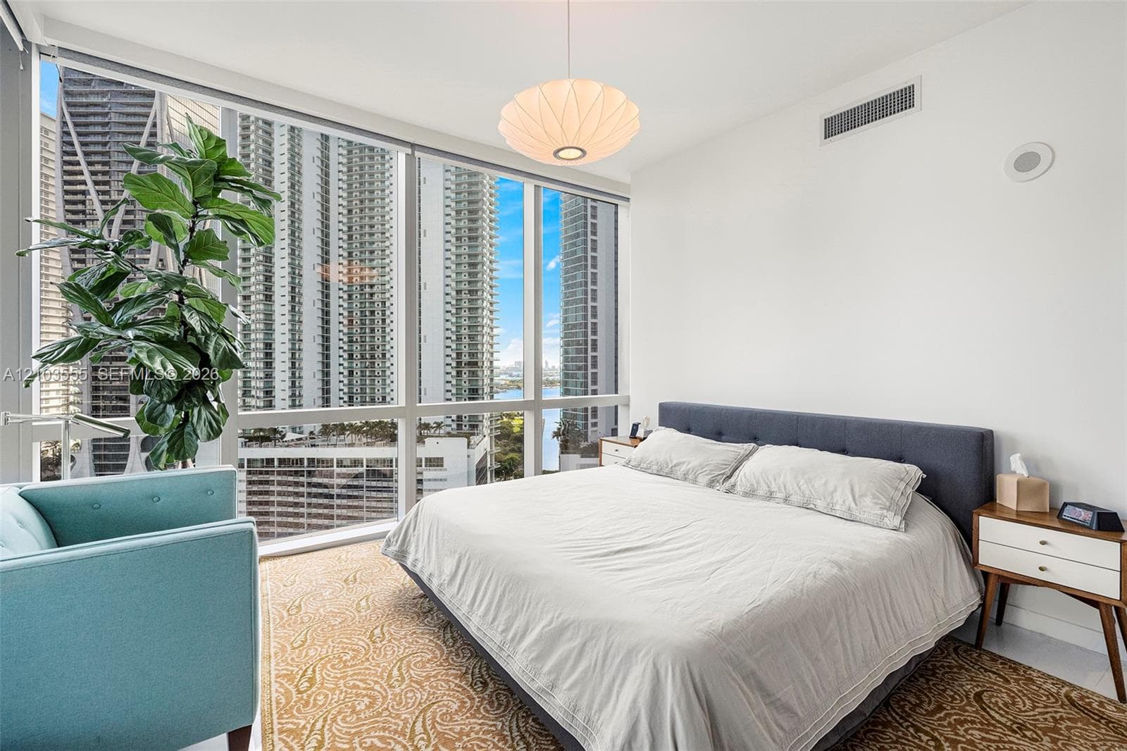Floor-to-ceiling windows with roller shades, recessed ceiling lighting, and a modern pendant light fixture