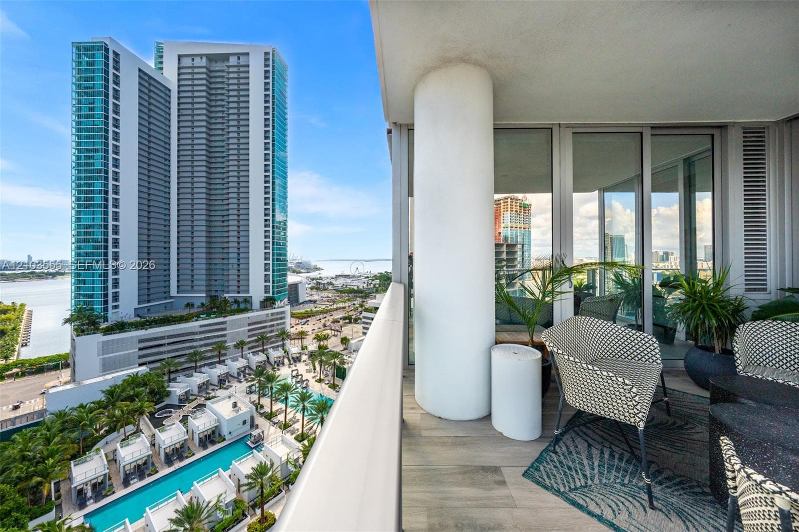 Balcony featuring an exterior column, sliding glass doors, and light-toned flooring