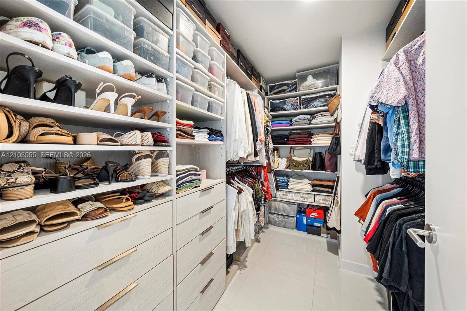Custom built-in closet system featuring multiple shelving units, integrated drawer storage with linear pull hardware, and dedicated hanging rods