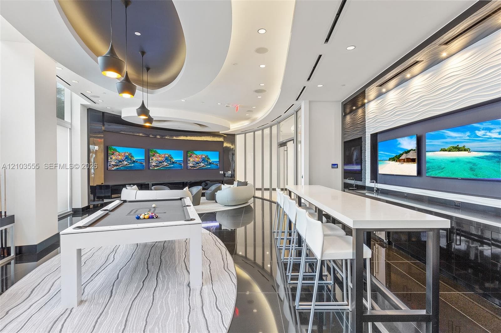 Curved architectural ceiling design with recessed lighting, multiple integrated wall displays, a sleek billiards table, a long counter bar, and reflective flooring