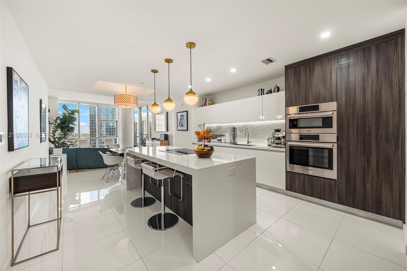 Contemporary kitchen with a white waterfall island, wood-finish cabinetry, and integrated stainless-steel appliances
