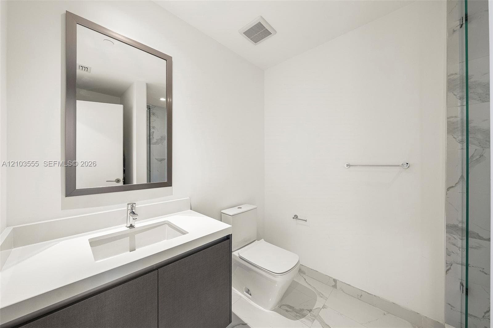 Contemporary vanity with an integrated rectangular sink, chrome faucet, and spacious countertop