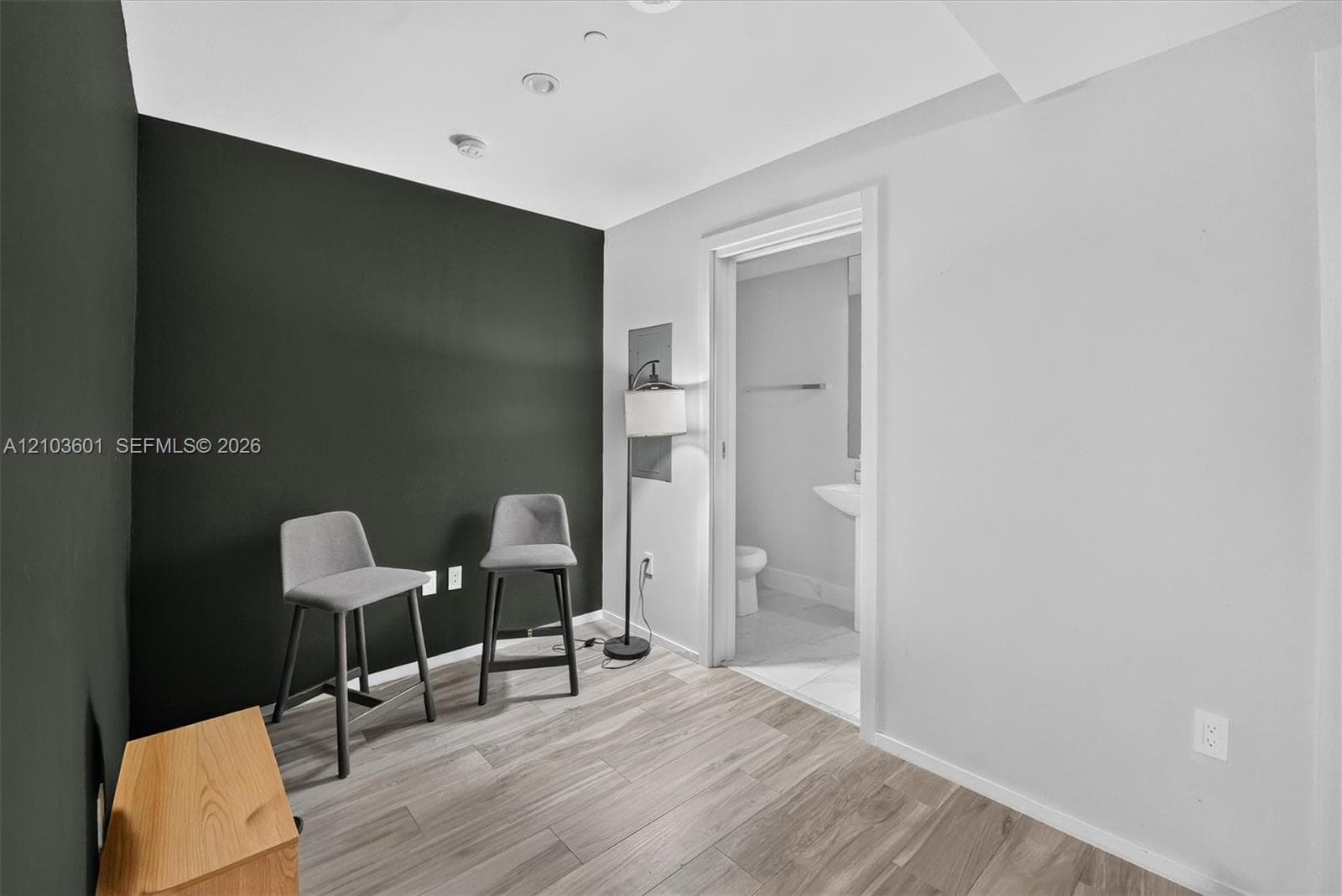 Wood-finish flooring, recessed lighting, and a distinct charcoal-toned accent wall