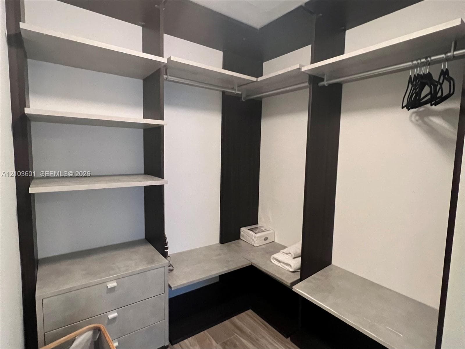 Kitchen featuring flat-panel wood-finish cabinetry, white countertops, a double-basin undermount sink with a gooseneck faucet, a built-in oven, and wood-finish flooring