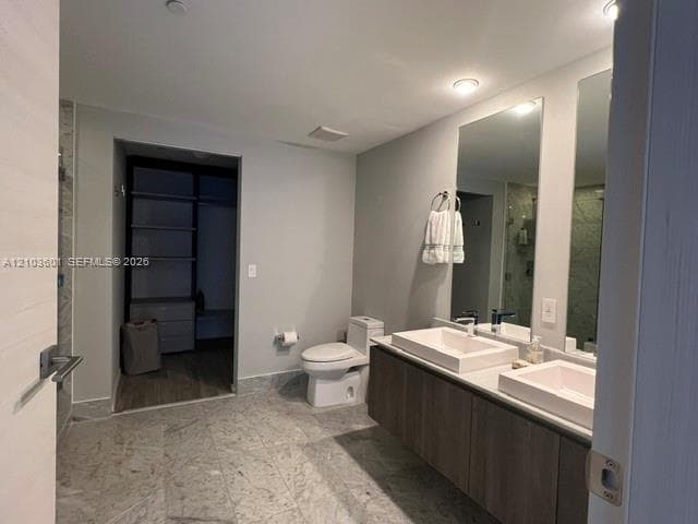Solid-surface countertop with an integrated stainless steel dual-basin sink, wood-finish cabinetry, built-in dishwasher, and a multi-arm modern light fixture