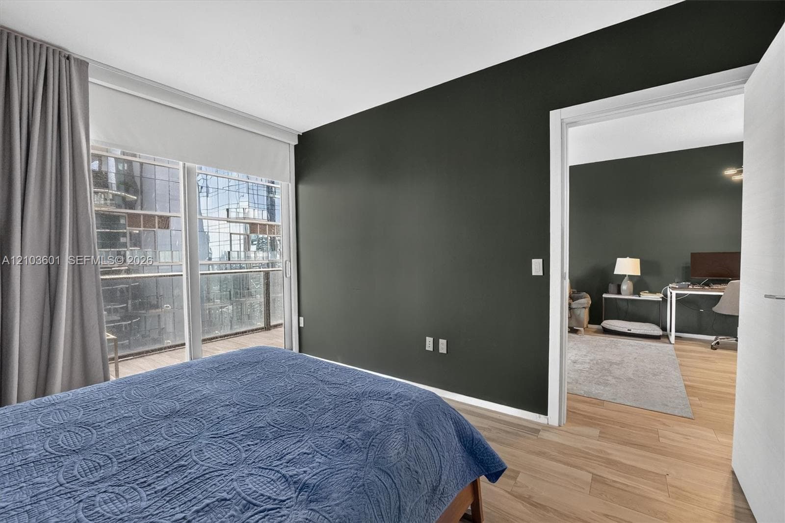 Interior space featuring wood-finish flooring, floor-to-ceiling glass sliding doors, and a private balcony