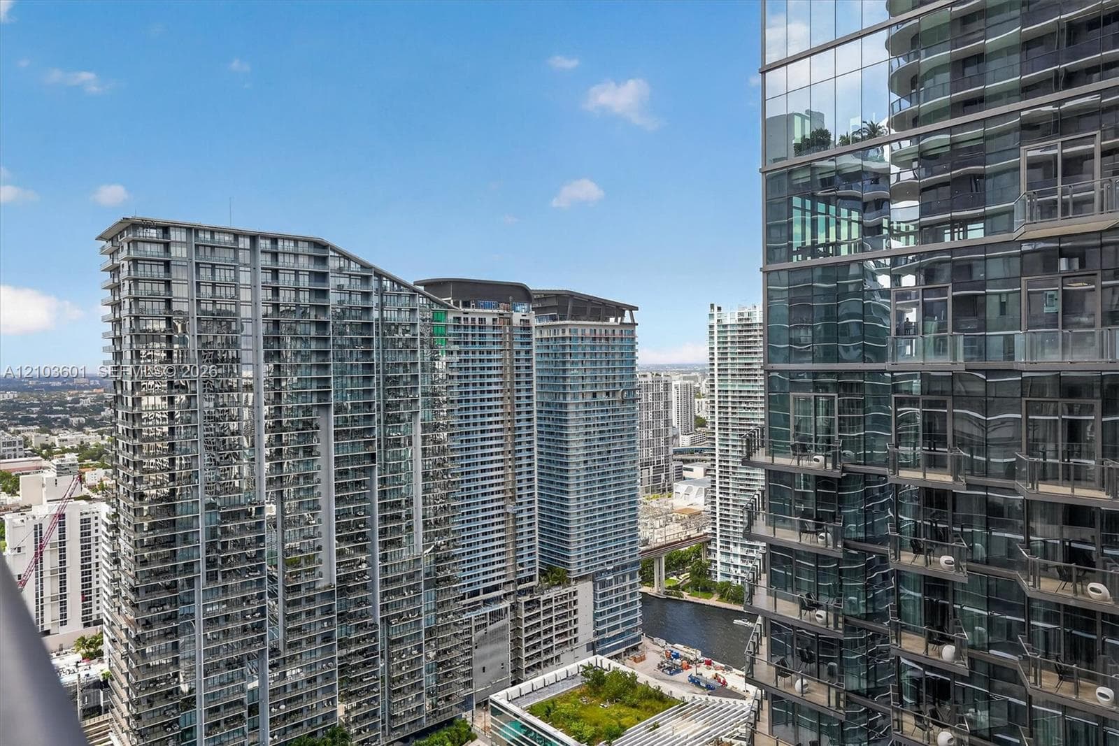 High-rise urban landscape featuring glass-clad towers with balconies and a waterway