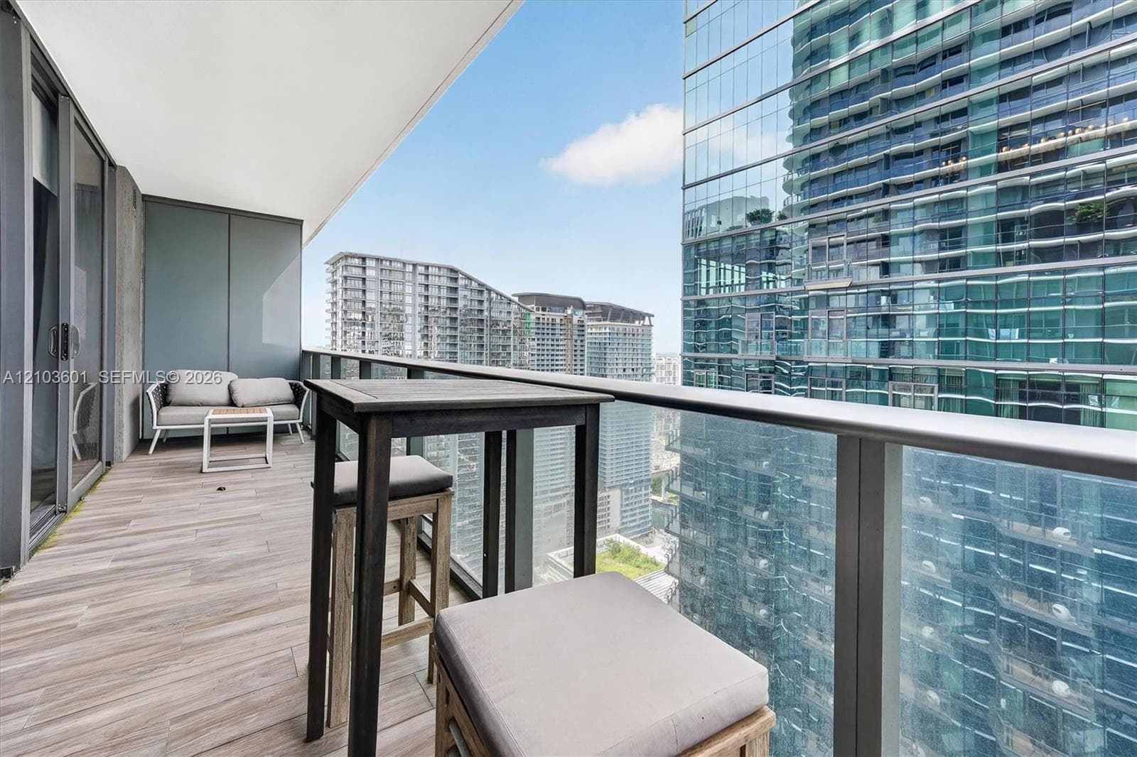 Covered balcony featuring wood-finish flooring and a glass panel railing