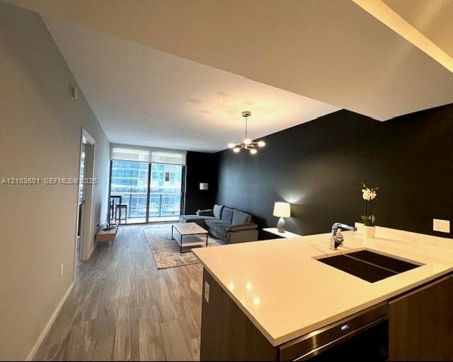 Built-in white storage cabinetry featuring a floor-to-ceiling wardrobe, upper shelving, a central wall-mounted coat rack, and a bench with an integrated drawer, complemented by wood-finish flooring
