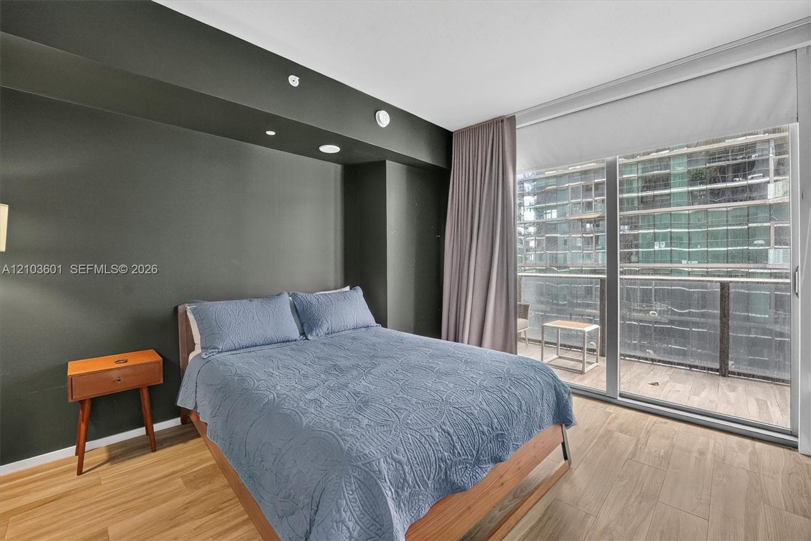 Floor-to-ceiling glass sliding doors, wood-finish flooring, and recessed ceiling lighting