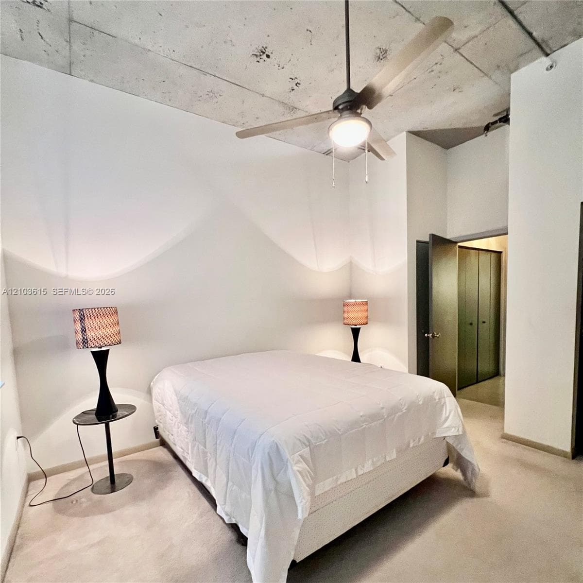 Exposed concrete ceiling, neutral wall finishes, integrated ceiling fan with light fixture, and built-in closet cabinetry